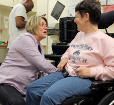 Occupational therapist Maura Mirecki makes an adjustment to Bari-Kim's new wheelchair.